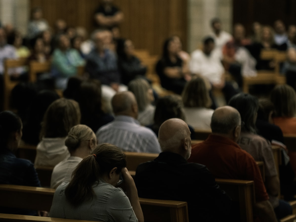 Gemeinde sitzt gemeinsam während eines Gottesdienstes in einer Kirche