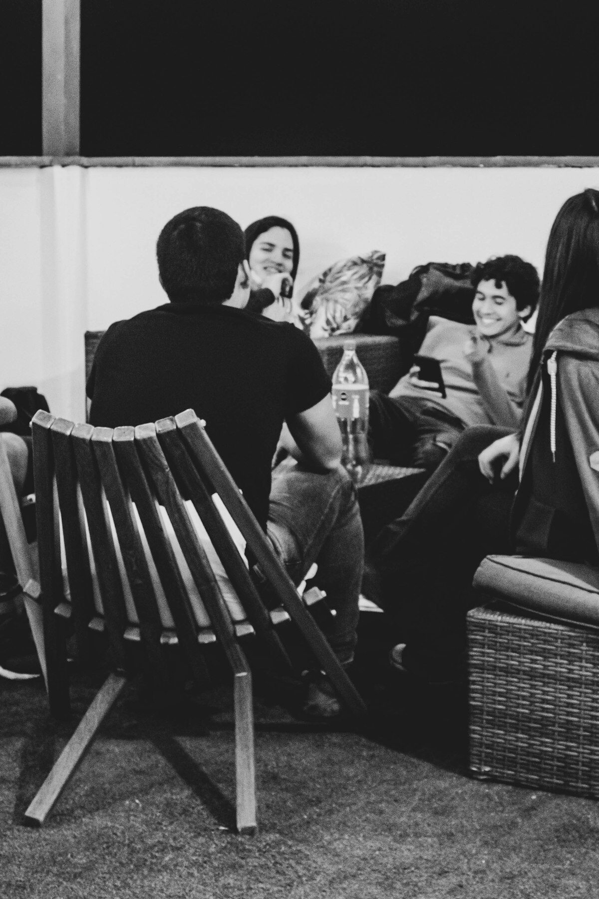 Kleine Gruppe sitzt gemeinsam auf einer Bank und unterhält sich